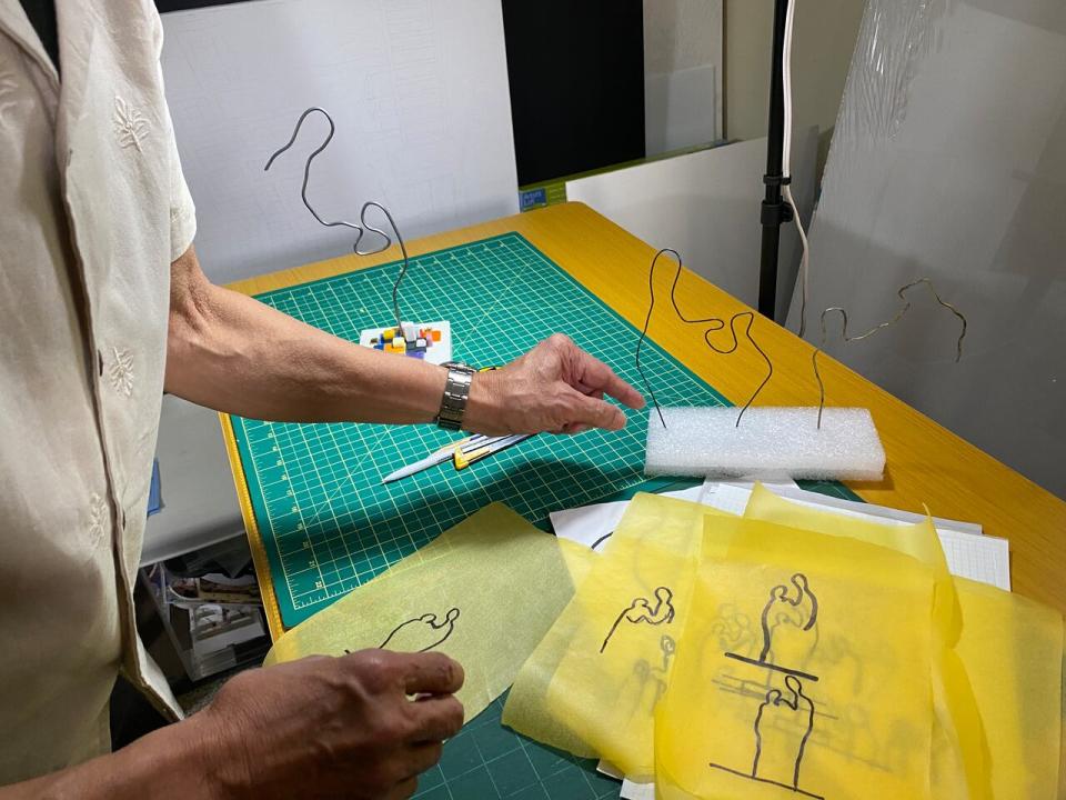 Pepito Escanlar shows steps in his artistic process, of drawing an outline of 'mano po,' that translated into the finished sculpture.