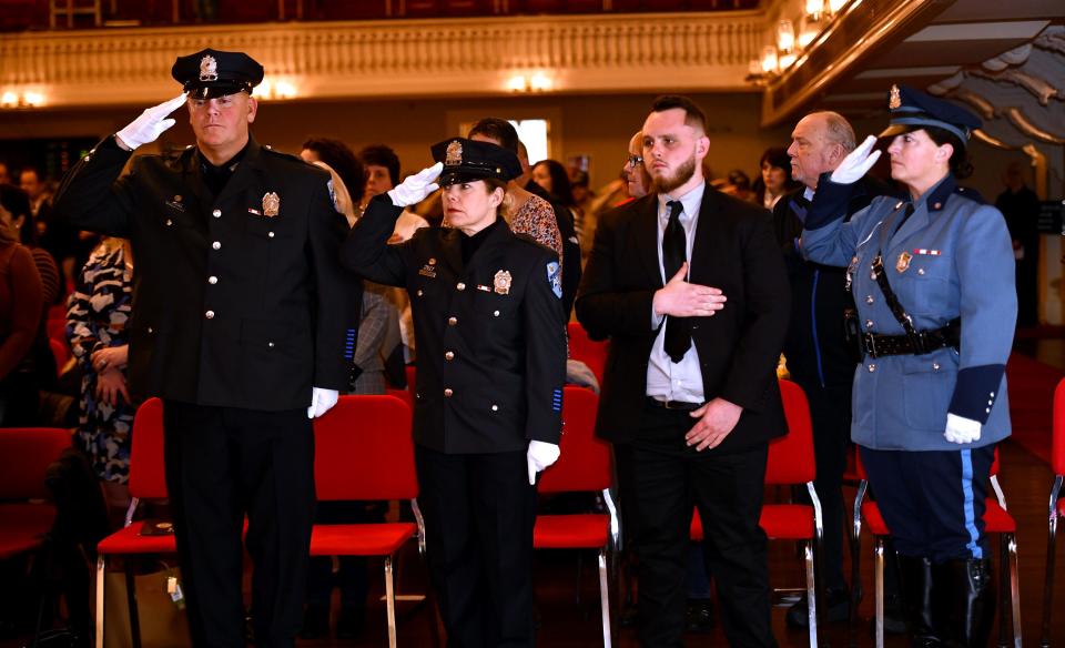 Worcester police Officers Steven Barnett, left, Officer Angela Consiglio, Scott Morin's brother, Patrick, and Massachusetts State Trooper Amy Waterman, salute for the national anthem.