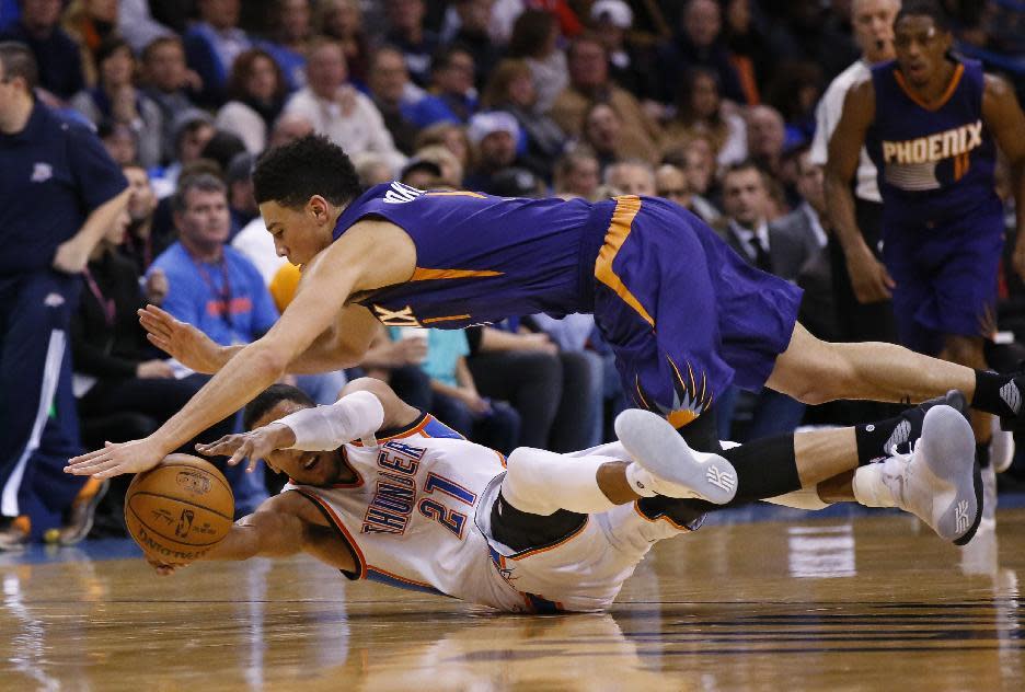 Oklahoma City Thunder forward Andre Roberson (21) and Phoenix Suns guard Devin Booker (1) dive for a loose ball in the first quarter of an NBA basketball game in Oklahoma City, Saturday, Dec. 17, 2016. (AP Photo/Sue Ogrocki)