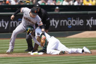 Oakland Athletics' Starling Marte, bottom, steals third base against San Francisco Giants' Wilmer Flores during the first inning of a baseball game in Oakland, Calif., Saturday, Aug. 21, 2021. (AP Photo/Jeff Chiu)