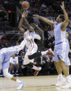 Iowa State's Dustin Hogue (22) is fouled by North Carolina's J.P. Tokoto, left, as he tries to scored during the first half of a third-round game in the NCAA college basketball tournament Sunday, March 23, 2014, in San Antonio. North Carolina's Kennedy Meeks (3) also defends on the play. (AP Photo/Eric Gay)