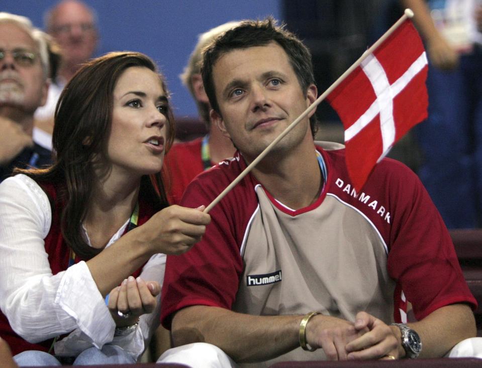 FILE - Crown Prince Frederik, right, and Crown Princess Mary of Denmark speak, prior to the start of the Olympic Group B women's handball match between Denmark and France in the Faliro Sports Pavilion, at the Olympic Games 2004 in Athens, Sunday, Aug. 15, 2004. The 55-year-old takes over the crown on Sunday, Jan. 14, 2024 from his mother, Queen Margrethe II, who is breaking with centuries of Danish royal tradition and retiring after a 52-year reign. (AP Photo/Andrew Medichini, File)