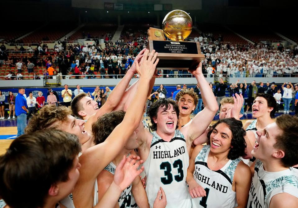 Highland senior Noah Peterson (33) and his teammates lift the 6A Championship trophy after beating Brophy in double overtime at Veterans Memorial Coliseum in Phoenix on March 4, 2023.