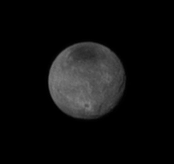 This photo of Charon, taken by NASA’s New Horizons spacecraft on July 11, 2015, highlights the big Pluto moon’s intriguing dark polar cap and shows probable craters and canyons as well.