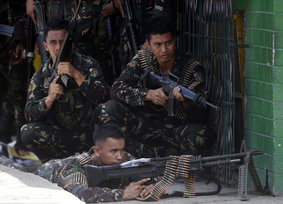 Government soldiers battling Moro National Liberation Front rebels take up positions in downtown Zamboanga city, in southern Philippines September 11, 2013. Rebels launched an audacious assault in the southern Philippines on Monday, taking control of several villages and shutting down a major port in the biggest challenge to a peace deal signed by the government last year. REUTERS/Erik De Castro (PHILIPPINES - Tags: CIVIL UNREST MILITARY POLITICS)