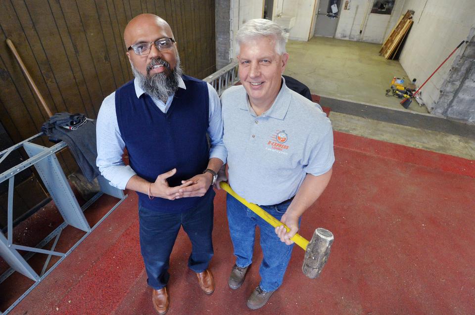 Business partners Ankur Shah, 44, left, and Kevin Kujan, 62, stand inside the former Train Shop in Wesleyville on Nov. 26. The owners of D-Express Laundry, near West 12th Street and Powell Avenue in Millcreek Township, will open a second location in Wesleyville. After knocking down walls, back left, the new eastside location will be about 3,400 square feet or almost twice the size of the original location.
