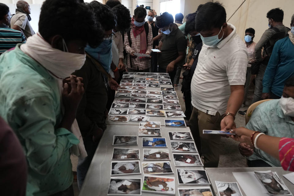 People look at the photographs of the passengers who were traveling in the trains that got derailed for identification in Balasore district, in the eastern Indian state of Orissa, Sunday, June 4, 2023. Indian authorities end rescue work and begin clearing mangled wreckage of two passenger trains that derailed in eastern India, killing over 300 people and injuring hundreds in one of the country’s deadliest rail crashes in decades. (AP Photo/Rafiq Maqbool)