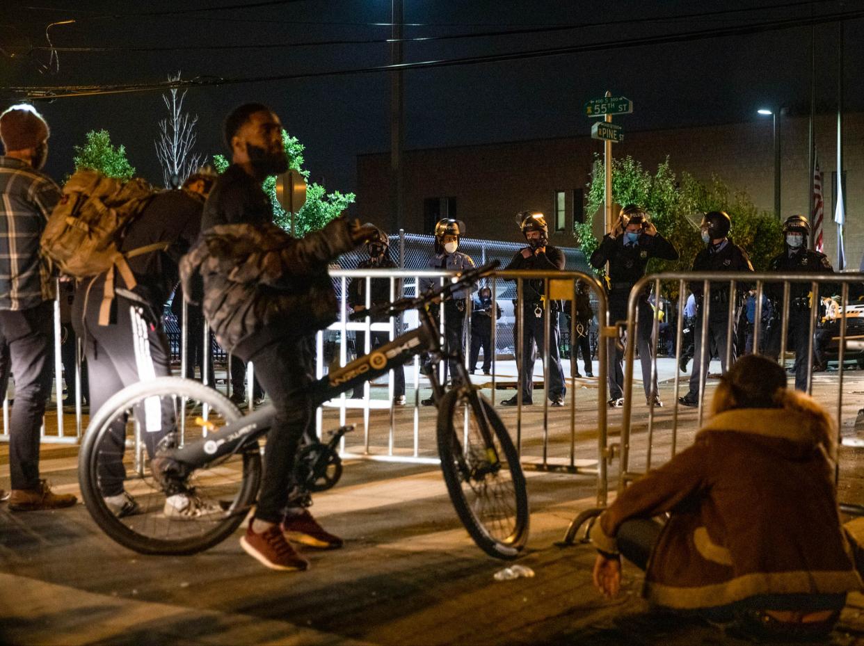 A group of protesters face police barricading the 18th Police Precinct after the city imposed a 9pm curfew in Philadelphia, (AFP via Getty Images)