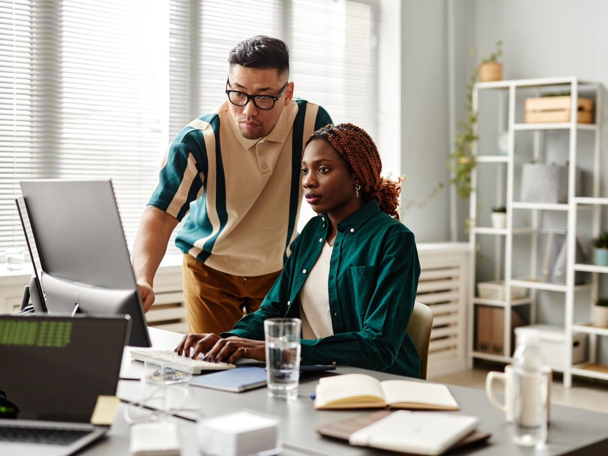 Two tech workers or office workers looking at a computer