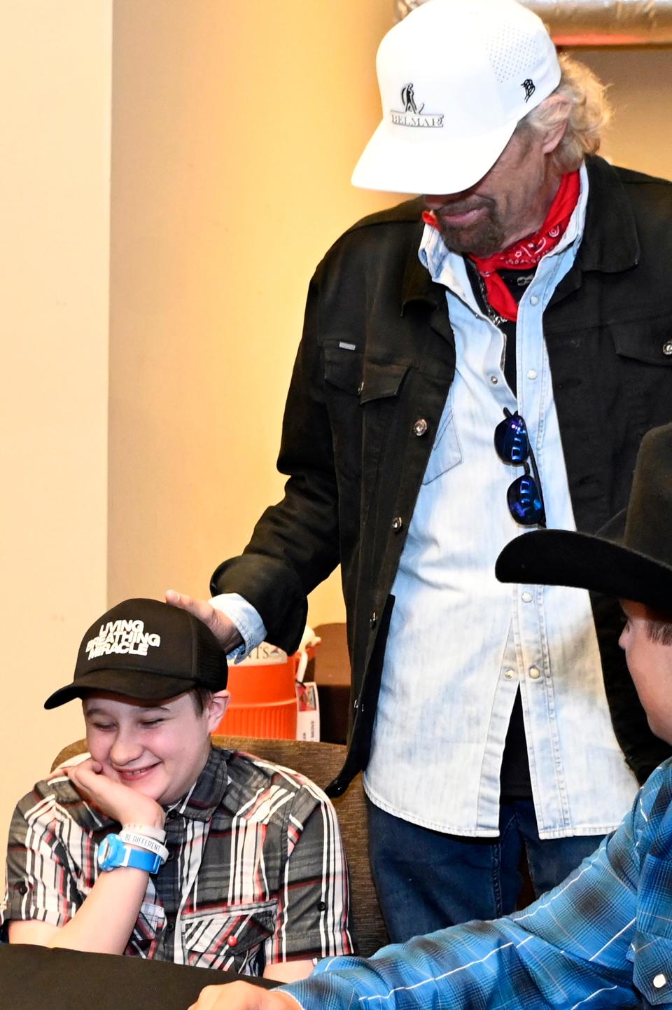 Toby Keith touches Rylyn Weigel's head June 2, 2023, at Riverwind Casino in Norman. Part of the 19th annual Toby Keith & Friends Golf Classic, a denim and diamonds-themed dinner and auction at the casino raised funds for the Toby Keith Foundation's OK Kids Korral in Oklahoma City.