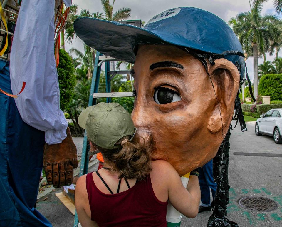Marley Monacello gets set to put the head on a 16-foot farmworker puppet named Esperanza on the third and final day of the Farmworker Freedom Festival on Sunday, across the street from the Palm Beach home of Wendy's board chairman Nelson Peltz.