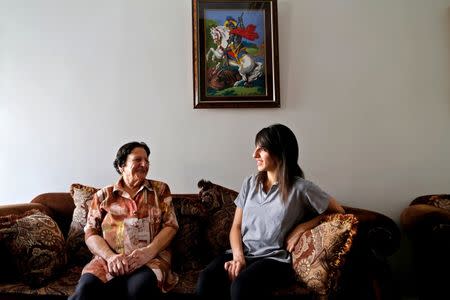 Palestinian swimmer Mary Al-Atrash (R), 22, who will represent Palestine at the 2016 Rio Olympics, sits with her grandmother in Beit Sahour, near the West Bank town of Bethlehem, June 27, 2016. REUTERS/Ammar Awad