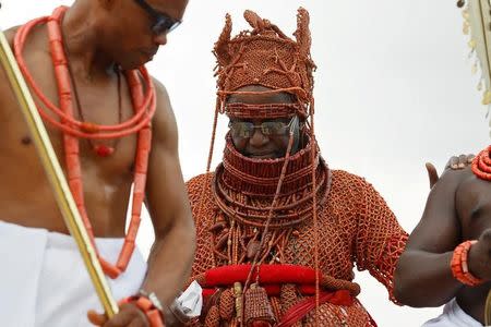 Newly crowned Oba of Benin Kingdom Eheneden Erediauwa is guided through a symbolic bridge by the palace chiefs during his coronation in Benin city, Nigeria October 20, 2016.REUTERS/Akintunde Akinleye