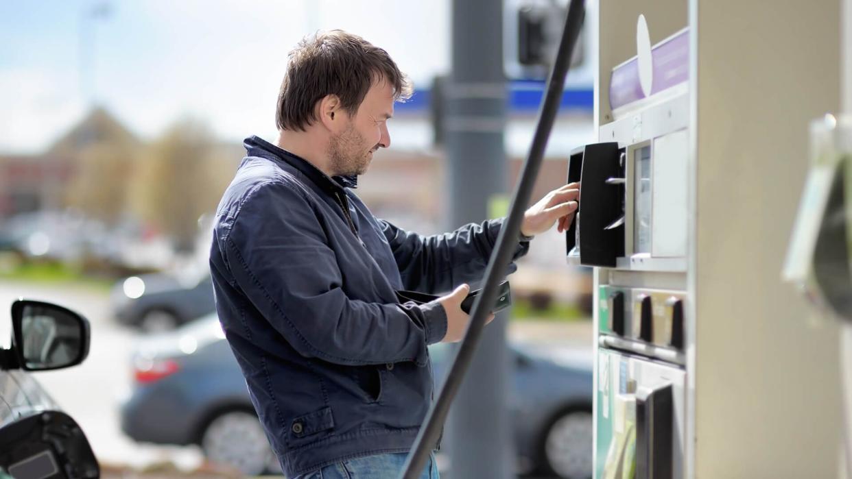 Man filling gasoline fuel in car holding nozzle.