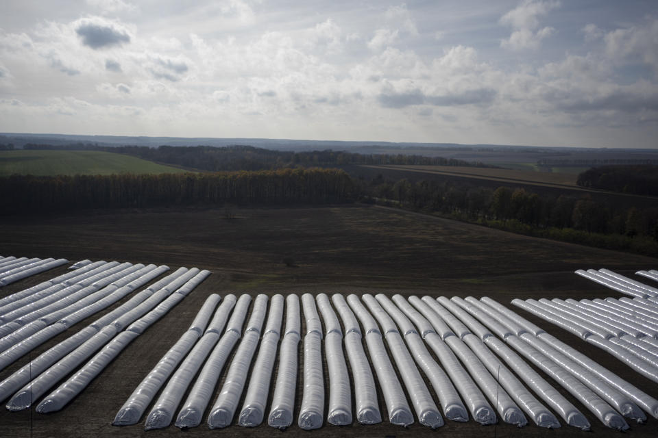 An overhead view of plastic silo bags filled with grain at a handling and storage facility in central Ukraine, Friday, Nov. 10, 2023. In recent months, an increasing amount of grain has been unloaded from overcrowded silos and is heading to ports on the Black Sea, set to traverse a fledgling shipping corridor launched after Russia pulled out of a U.N.-brokered agreement this summer that allowed food to flow safely from Ukraine during the war. (AP Photo/Hanna Arhirova)