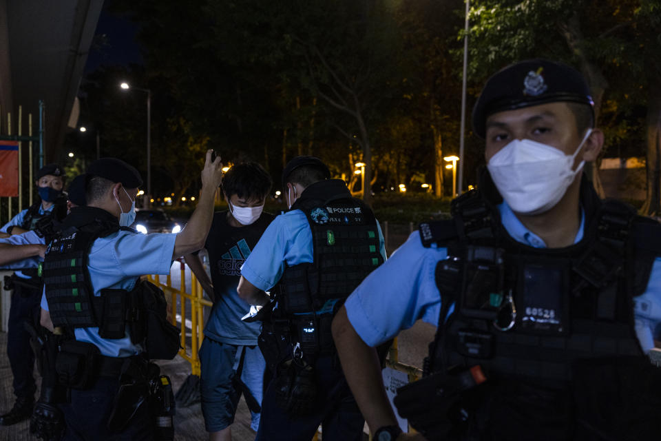 A member of the public is searched by police near Victoria Park, the city's venue for the annual 1989 Tiananmen massacre vigil, on the 34th anniversary of China's Tiananmen Square crackdown in Hong Kong, Sunday, June 4 2023. (AP Photo/Louise Delmotte)