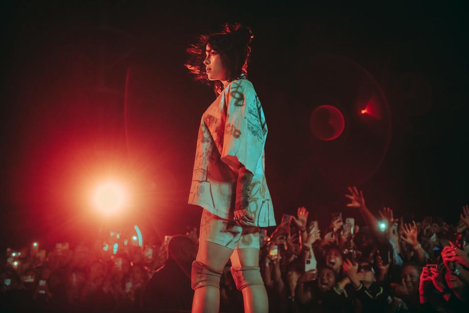 Billie Eilish, on the stage in April during the Coachella Valley Music and Arts Festival in Indio, Calif., says that performing helps calm her tics and other symptoms of Tourette's.