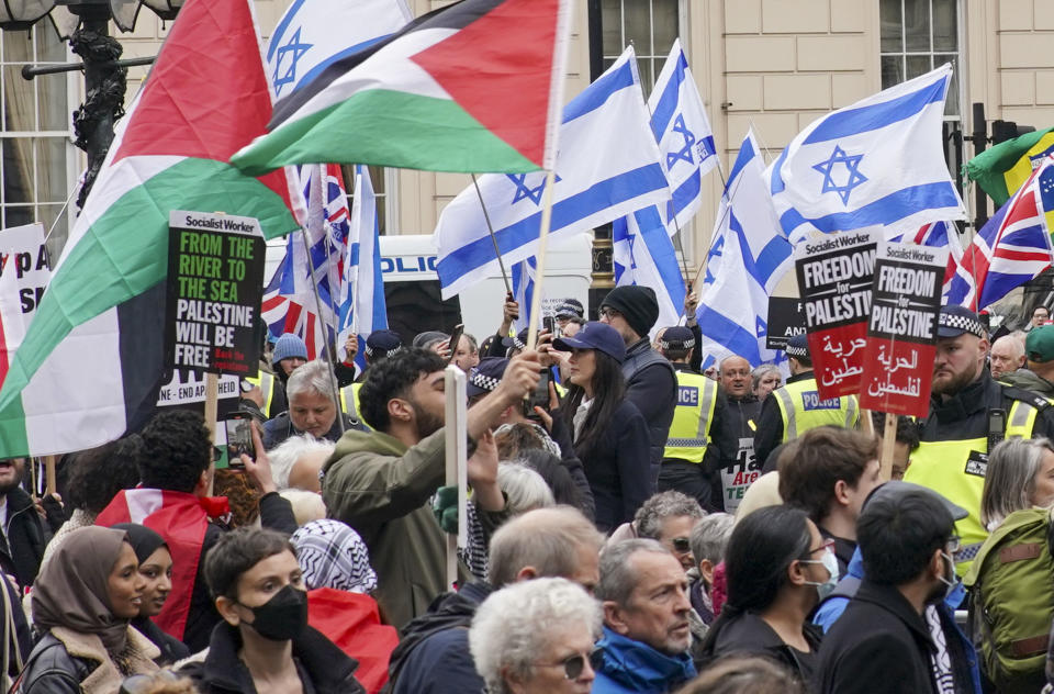 People take part in a pro-Palestine march as they walk past a counter protest with Israeli flags, at Waterloo Place in central London, Saturday, April 27, 2024. (Jeff Moore/PA via AP)