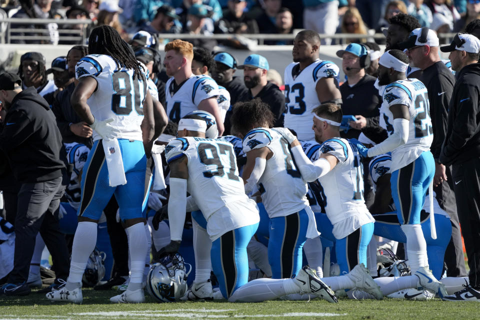 Members of the Carolina Panthers gather around linebacker Marquis Haynes Sr. after an injury during the second half of an NFL football game against the Jacksonville Jaguars Sunday, Dec. 31, 2023, in Jacksonville, Fla. (AP Photo/John Raoux)