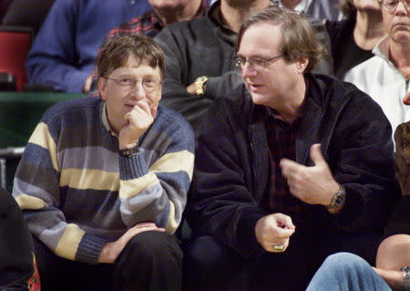 FILE PHOTO: Microsoft co-founders Bill Gates (L) and Paul Allen (R) chat at courtside during the NBA game between the Seattle SuperSonics and the Portland Trailblazers at Key Arena in Seattle, March 11, 2003. REUTERS/Anthony P. Bolante/File Photo