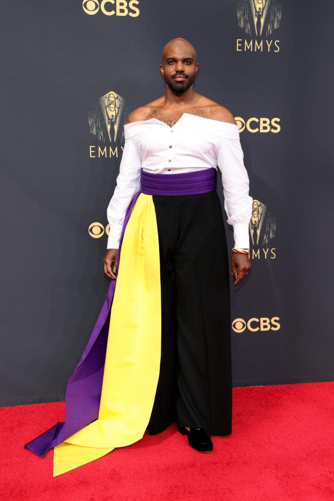 Carl Clemons-Hopkins looking stunning in white off-the-shoulder top, purple and yellow waist sash.