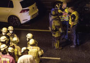 Police officers and fire fighters work on the scene following several accidents on the city motorway A100 in Berlin, Germany, Tuesday, Aug. 18, 2020. According to German news agency dpa, prosecutors say the series of crashes caused by a 30-year-old Iraqi man on the highway was an Islamic extremist attack. (Paul Zinken/dpa via AP)