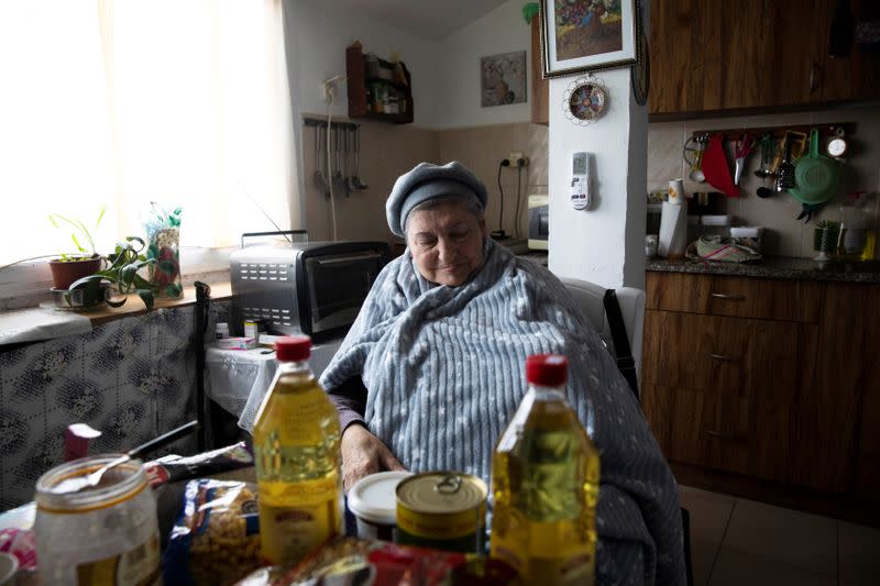 Holocaust survivor Maya Shulman, 88, looks at food items, part of a donation she received from Chasdei Naomi, a non-profit organisation that provides help to thousands of Holocaust survivors in Israel, in Beit Shemesh, Israel