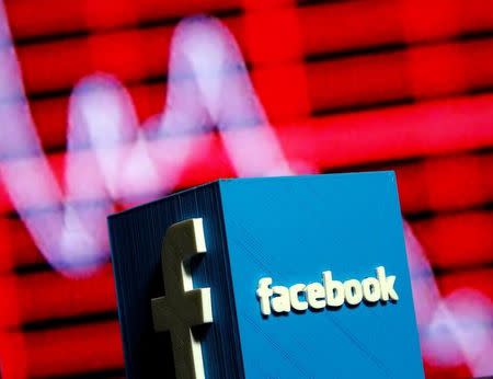 A 3D-printed Facebook logo is seen in front of a displayed stock graph in this illustration taken November 3, 2016. REUTERS/Dado Ruvic/Illustration