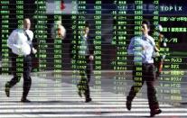 Pedestrians are reflected on a stock quotation board at a brokerage in Tokyo November 26, 2013. REUTERS/Yuya Shino