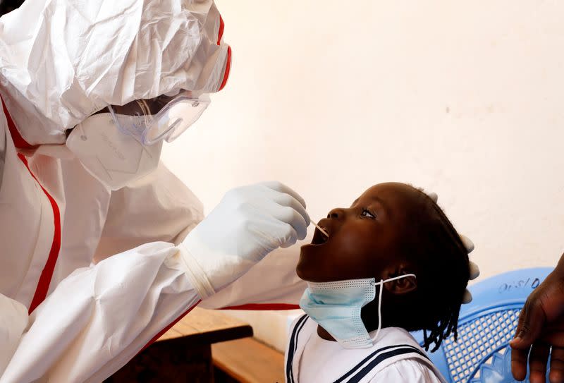 A health worker takes a swab from a child during a mass testing in an effort to stop the spread of the coronavirus disease (COVID-19) in the Kibera slum of Nairobi