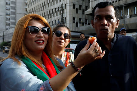 Supporters of Pakistan Tehreek-e-Insaf (PTI) party, distribute sweets as they celebrate, after cricketer-turned-politician Imran Khan was sworn in as prime minister of Pakistan, in Karachi, Pakistan August 18, 2018. REUTERS/Akhtar Soomro