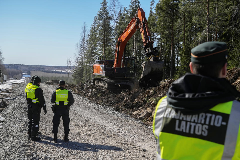 Finland's border guards stay at construction site of the border barrier fence between Finland, right, and Russia, near Pelkola border crossing point in Imatra, south-eastern Finland, Friday, April 14, 2023. (AP Photo/Sergei Grits)