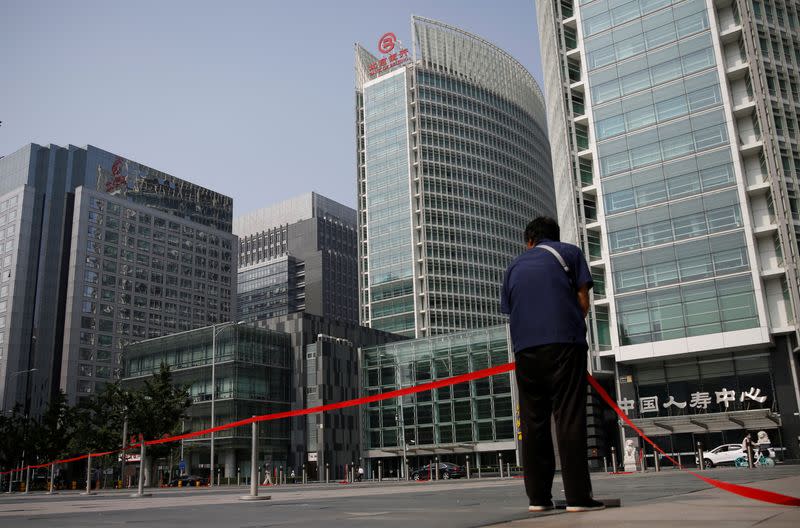 Worker wearing a face mask following the outbreak of the coronavirus disease (COVID-19) sets up a line at a square at the Financial Street area in Beijing