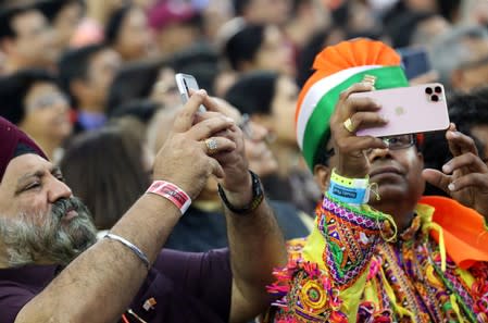 People take photos with their mobile phones as they participate in the "Howdy Modi" event in Houston