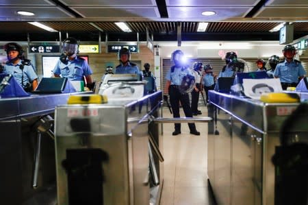 Riot police stand guard inside Sha Tin Mass Transit Railway (MTR) station as anti-government protesters gather to demonstrate against the railway operator, which they accuse of helping the government, in Hong Kong