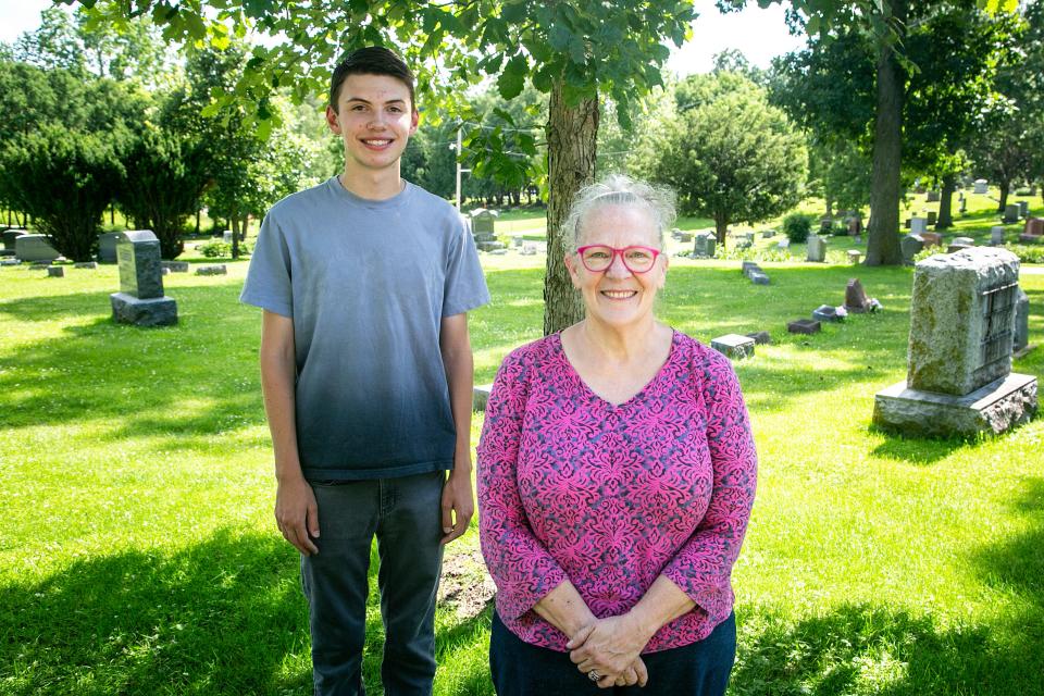 Aaron Schultz, left, and Madonna White pose for a photo after cleaning headstones of veterans, Tuesday, July 12, 2022, at Oakland Cemetery in Iowa City, Iowa.