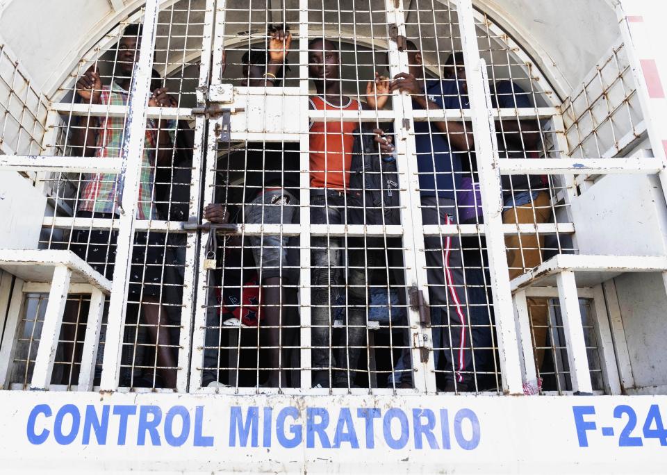 Detained Haitians slated for deportation stand in a police truck on a border bridge between Dajabón, Dominican Republic, and Haiti, Thursday, Sept. 14, 2023. The president of the Dominican Republic announced Thursday that he would close all borders with neighboring Haiti starting Friday in response to the construction of a supposed canal on Haitian soil that targets waters from the Massacre River, which runs along the border shared by both countries. (AP Photo/Ricardo Hernández)