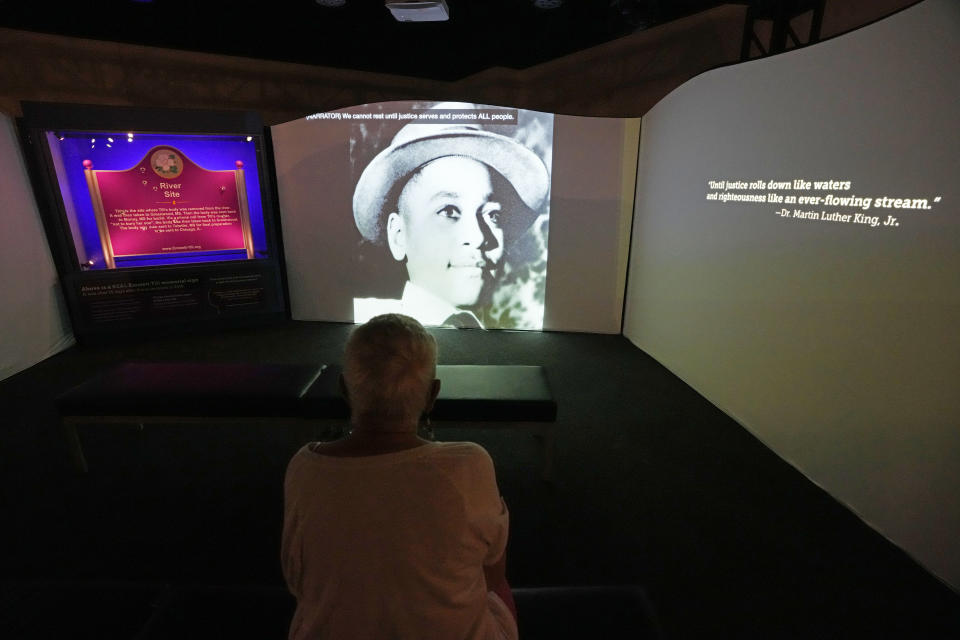 A visitor to the Two Mississippi Museums watches a video in the "Emmett Till and Mamie Till-Mobley Let The World See" exhibit that examines the story of Black teenager Emmett Till who was accused by Carolyn Bryant of making improper advances before he was lynched in Mississippi in 1955, Thursday, April 27, 2023, in Jackson, Miss. Till's kidnapping and killing became a catalyst for the civil rights movement when his mother insisted on an open-casket funeral in their hometown of Chicago after his brutalized body was pulled from a river in Mississippi. Carolyn Bryant Donham died, Tuesday, April 25, in hospice care in Louisiana. She was 88. (AP Photo/Rogelio V. Solis)