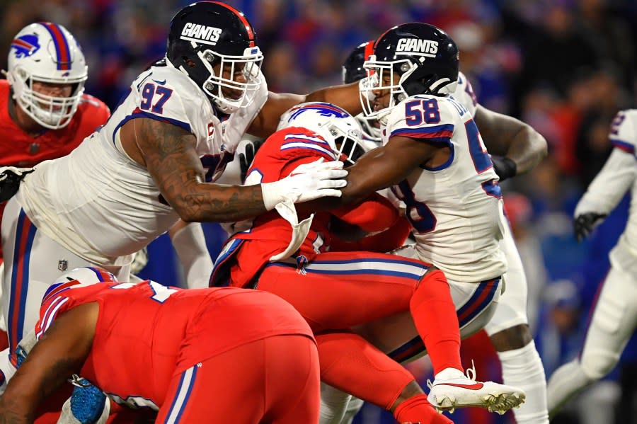 Buffalo Bills running back Damien Harris, center, is hit by New York Giants linebacker Bobby Okereke (58) and defensive lineman Dexter Lawrence II (97) during the first half of an NFL football game in Orchard Park, N.Y., Sunday, Oct. 15, 2023. Harris was injured on the play. (AP Photo/Adrian Kraus)