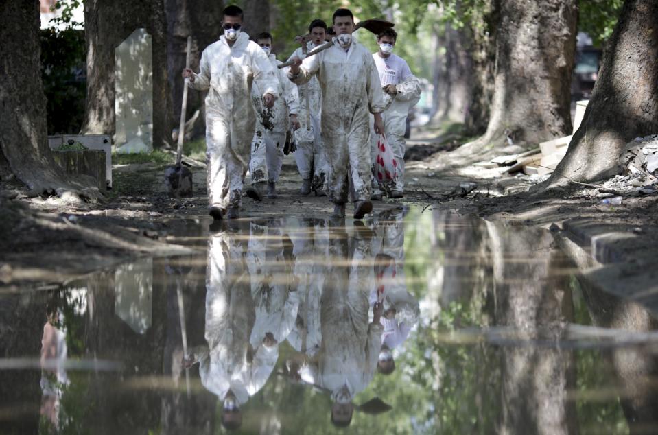 Volunteers walk after cleaning up at the site of a flood in Maglaj