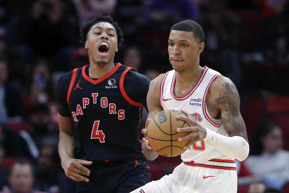 Houston Rockets forward Jabari Smith Jr., right, pulls down a rebound in front of Toronto Raptors forward Scottie Barnes (4) during the second half of an NBA basketball game Friday, Feb. 2, 2024, in Houston. (AP Photo/Michael Wyke)