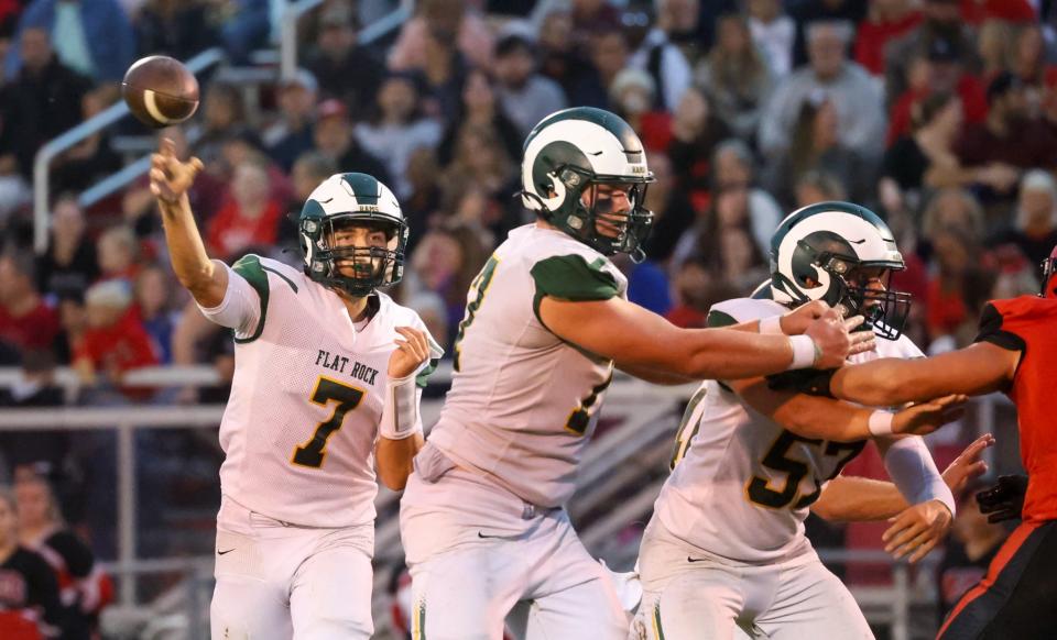 Robert Percha (77) and Carter Aicher (57) block as Flat Rock Graham Junge throws the ball. Junge threw for 2,419 yards this season, falling just shy of the Region record he set last year.