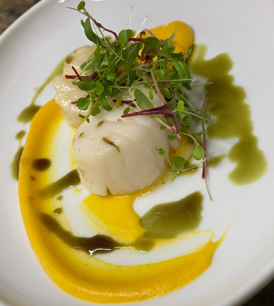 Poached Viking Village scallops with carrot coulis.