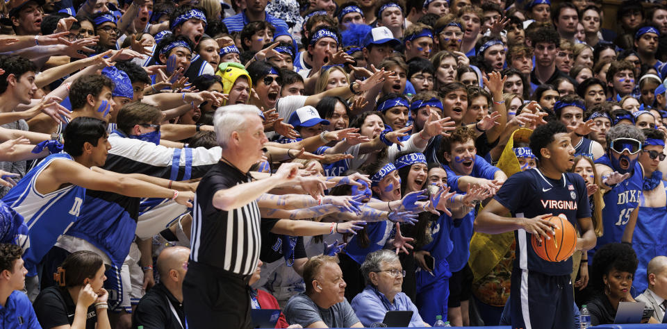Virginia's Reece Beekman, right, in-bounds the ball ahead of the Duke student section during the second half of an NCAA college basketball game in Durham, N.C., Saturday, Mar. 2, 2024. (AP Photo/Ben McKeown)