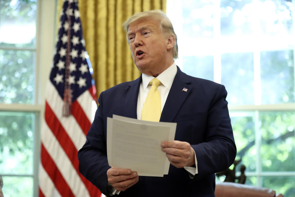 President Donald Trump holds a letter as he meets with Chinese Vice Premier Liu He in the Oval Office of the White House in Washington, Friday, Oct. 11, 2019. (AP Photo/Andrew Harnik)