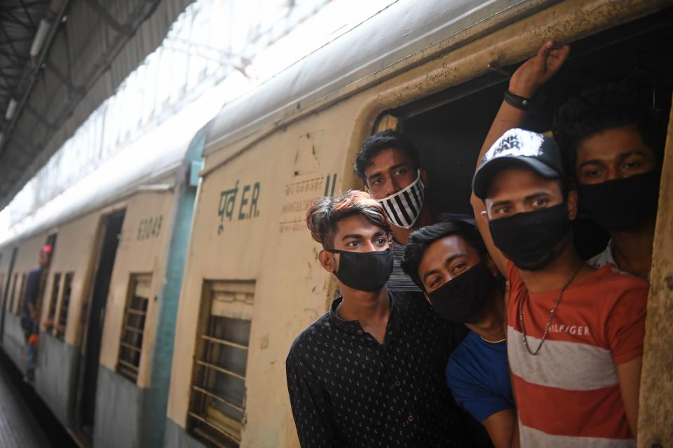 Passengers wearing facemasks travel in a train during a one-day Janata (civil) curfew imposed as a preventive measure against the COVID-19 coronavirus, at a railway station in Kolkata on March 22, 2020. - Nearly one billion people around the world were confined to their homes, as the coronavirus death toll crossed 13,000 and factories were shut in worst-hit Italy after another single-day fatalities record. (Photo by Dibyangshu SARKAR / AFP) (Photo by DIBYANGSHU SARKAR/AFP via Getty Images)
