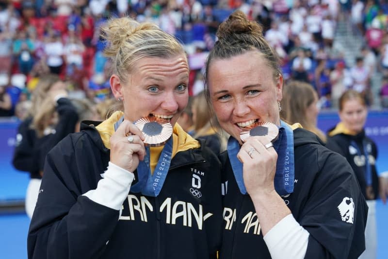 Die Deutschen Marina Hegering (rechts) und Alexandra Popp feiern ihre Bronzemedaille nach dem Frauenfußball-Goldmedaillenspiel zwischen den USA und Brasilien im Parc des Princes am fünfzehnten Tag der Olympischen Spiele 2024 in Paris. Marcus Brandt/dpa