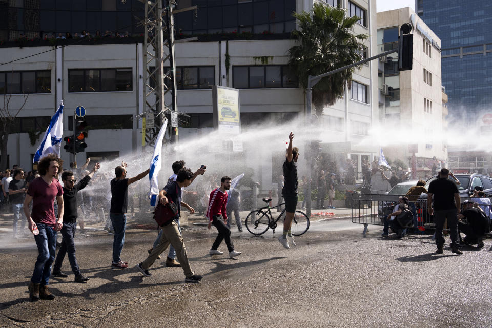 Israeli police deploy a water cannon to disperse Israelis blocking a main road during a protest against plans by Prime Minister Benjamin Netanyahu's new government to overhaul the judicial system, in Tel Aviv, Israel, Wednesday, March 1, 2023. (AP Photo/Oded Balilty)
