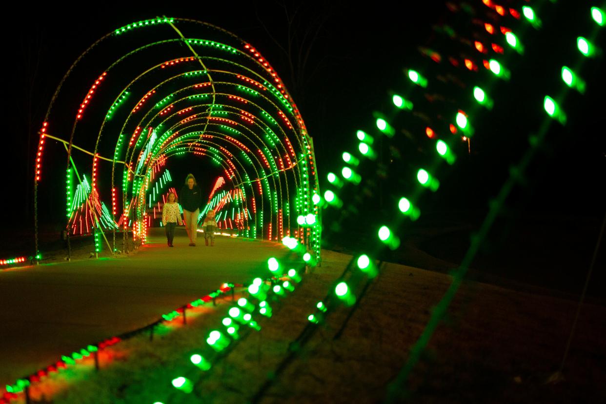 Aleisha Thompson walks with her sons Logan and Jack through a holiday light exhibition at Riverwalk Park in Columbia, Tenn., on Monday, Dec. 13, 2021.