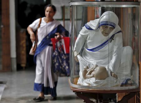 A woman walks past a statue of Mother Teresa ahead of Teresa's 100th birth anniversary in Kolkata, India, in this August 25, 2010 file photo. REUTERS/Rupak De Chowdhuri/Files